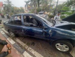 Sebuah sedan menabrak tiang listrik setelah oleng dan naik ke trotoar di Jl. Chairil Anwar Depan Mall Blue Plaza